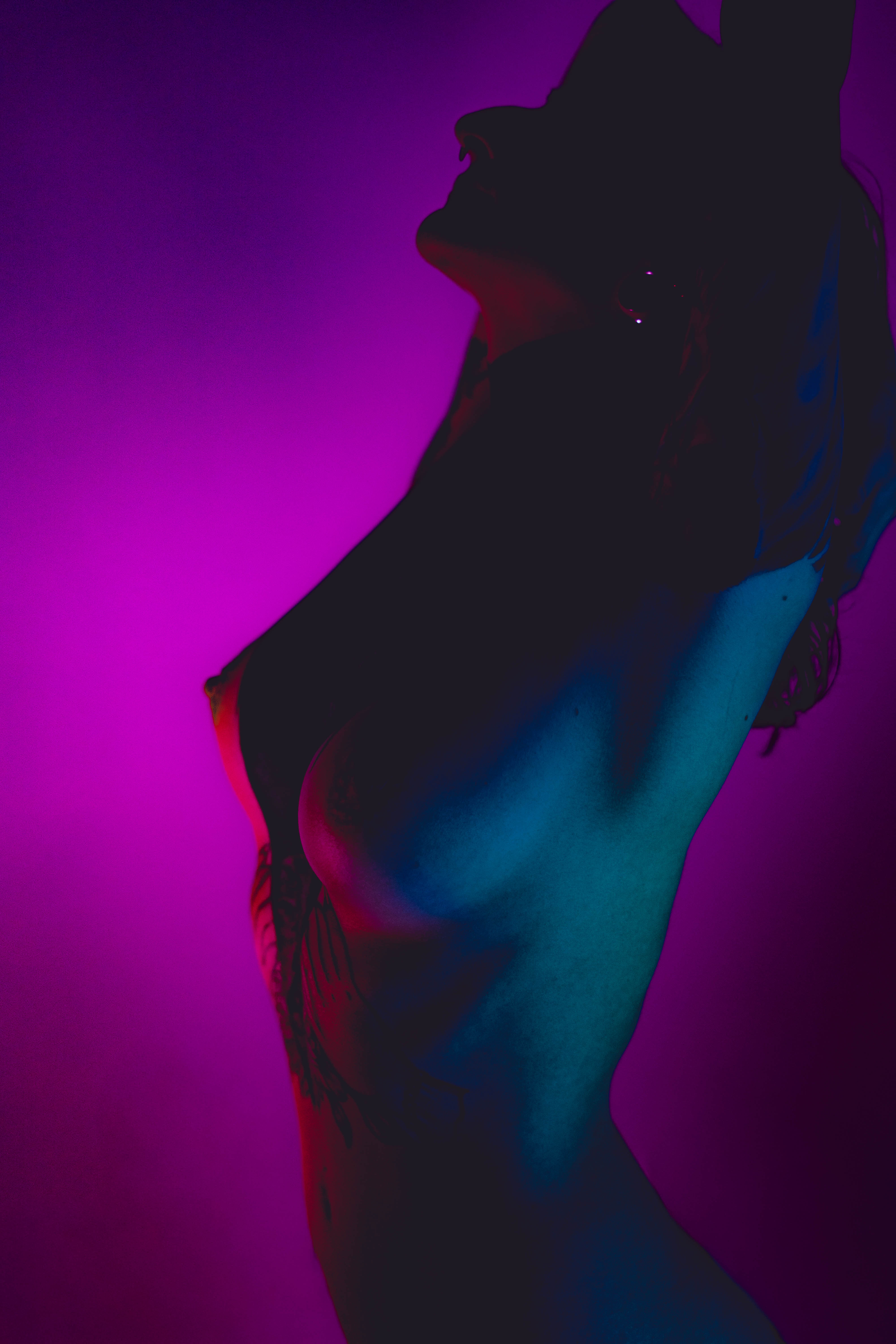 Muse reference photograph by Samma Charles — nude figure in profile under purple and teal light, head tilted back